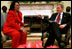 President George W. Bush and Coretta Scott King, the widow of Dr. Martin Luther King, Jr., share a laugh in the Oval Office Jan. 21, 2002. President George W. Bush honored Dr. King in a White House celebration and received a portrait of the civil rights leader from his wife and children in the East Room.