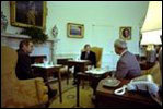 While sitting in front of the fireplace in the Oval Office February 7, 1977, President Jimmy Carter hosts a lunch for Vice President Mondale and energy adviser James Schlesinger. Hanging above the mantel is Charles Willson Peale's portrait of George Washington, which President Carter acquired for the White House's permanent art collection.