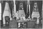 While working at his desk in the Oval Office, which he had moved to its current location in 1934, President Franklin Roosevelt meets with Marguerite Le Hand, his personal secretary.