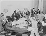 Reporters jump over tables in the White House to pick up press releases about the Japanese surrender, August 14, 1945.