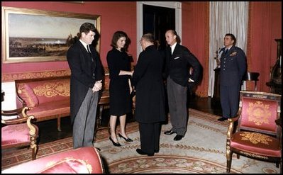 With her brother-in-law Edward Kennedy at her side, Jacqueline Kennedy greets guests in the Red Room following the funeral for her husband, President John Kennedy.