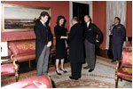 With her brother-in-law Edward Kennedy at her side, Jacqueline Kennedy greets guests in the Red Room following the funeral for her husband, President John Kennedy.