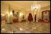 Entrances to both the East Room and the State Dining Room from the Cross Hall are surrounded by garlands full of large pine cones, red glass balls, red icicles and red pepper berries.