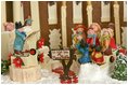 Singing carolers stand in front of the 2004 Gingerbread House and celebrate this year's theme, "A Season of Merriment and Melody".