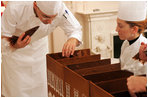 Head Pastry Chef Thaddeus DuBois and assistant Suzie Morrison glue together the foundation of the official White House gingerbread house using chocolate as the glue.