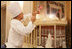 White House pastry chef Thaddeus DuBois tops off his gingerbread house with a flag, Wednesday, Nov. 30, 2005, in the State Dining Room, as the finishing touches are made to the White House Christmas decorations.