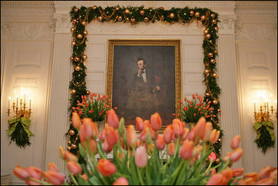 In the State Dining Room, President Lincoln’s portrait is framed by tulips and Boxwood Garland.