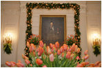 In the State Dining Room, President Lincoln’s portrait is framed by tulips and Boxwood Garland.