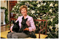 Laura Bush poses with Barney and Miss Beazley next to the White House Christmas Tree.