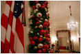 The doorways in the Cross Hall are outlined with boughs of evergreen garland and trimmed with glass ornaments, painted in red, green and silver.