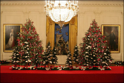 The White House has a total of 17 decorated Christmas trees. Two are placed next to the famous portraits of George and Martha Washington in the East Room. They are trimmed with silvered-glass ornaments painted in red and fuchsia. Between them, recessed in the wall is an elaborate nativity scene.