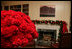 Red carnations in silver containers bloom as the centerpiece of the White House Library.