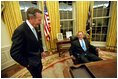 After being sworn in as the 43rd President of the United States, George W. Bush shares his first private moments in the Oval Office with his father, former President George H. W. Bush, Jan. 20, 2001.