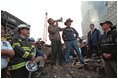 Standing on top of a crumpled fire truck with retired New York City firefighter Bob Beckwith, President George W. Bush rallies firefighters and rescue workers during an impromptu speech at the site of the collapsed World Trade Center towers Sept. 14, 2001. "I can hear you," President Bush said. "The rest of the world hears you. And the people who knocked these buildings down will hear all of us soon." 