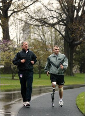 President George W. Bush runs with U.S. Army Staff Sergeant Michael McNaughton of Denham Springs, La., on the South Lawn of the White House Wednesday, April 14, 2004. The two met January 17, 2003 at Walter Reed Army Medical Center where SSgt. McNaughton was recovering from wounds sustained in Iraq. The President then wished SSgt. McNaughton a speedy recovery so that they might run together in the future.