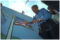 As American flags throughout the neighborhood furled in the breeze, the President made a few waves of his own helping local children paint an American flag July 4, 2001.