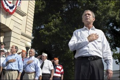 President George W. Bush joins war veterans on stage during the Pledge of Allegiance to open the "Saluting Our Veterans" Fourth of July Celebration in Ripley, West Virginia.