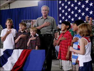 President George W. Bush joins a group of children during the Pledge of Allegiance Wednesday, July 4, 2007, at a Fourth of July visit with members of the West Virginia Air National Guard 167th Airlift Wing and their family members in Martinsburg, W. Va. White House photo by Chris Greenberg