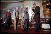 President George W. Bush salutes the Navajo Code Talkers during a ceremony at the U. S. Capitol July 26, 2001. "In war, using their native language, they relayed secret messages that turned the course of battle. At home, they carried for decades the secret of their own heroism," said the President who presented medals to 21 Native Americans who served during World War II.