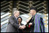 President George W. Bush and Afghanistan President Hamid Karzai shake hands after cutting the ceremonial ribbon, Wednesday, March 1, 2006, to dedicate the new U.S. Embassy Building in Kabul, Afghanistan. President Karzai thanked President Bush and the American people for their continued support to the Afghan people.