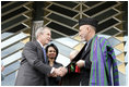 President George W. Bush and Afghanistan President Hamid Karzai shake hands after cutting the ceremonial ribbon, Wednesday, March 1, 2006, to dedicate the new U.S. Embassy Building in Kabul, Afghanistan. President Karzai thanked President Bush and the American people for their continued support to the Afghan people.