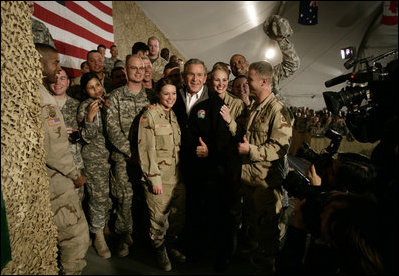 President George W. Bush poses for photos with U.S. and Coalition troops Wednesday, March 1, 2006, during a stopover at Bagram Air Base in Afghanistan, prior to his visit to India and Pakistan.