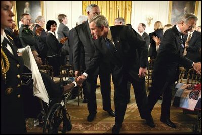 President George W. Bush speaks with Pvt. 1st Class Phillip Ramsey after signing The Emergency Supplemental Appropriations Act for Defense and for The Reconstruction of Iraq and Afghanistan in the East Room Nov. 6, 2003. “Today, the United States is making a critical financial commitment to this global strategy to defeat terror. We’re supporting our servicemen and women in the field of battle. We’re supporting reconstruction and the emergence of democratic institutions in a vital area of the world,” said President Bush during the signing ceremony.