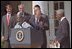 President George W. Bush welcomes UN Secretary General Kofi Annan to the podium after his announcement of Presidential HIV/AIDS Trust Fund Initiative as Nigerian President Olusegun Obsanjo looks on at left in the Rose Garden, Friday, May 11, 2001.