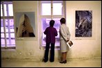 Laura Bush and Meda Mladek look over the rushing waters of the Vlatva River from an exhibit in Mladek's museum in Prague Thursday, November 21, 2002.The museum, known as the Kampa Museum, was severly damaged by flooding in August. The collection features artists who worked under the Soviet occupied government. A special exhibit on Sept. 11, 2001, sponsored by the U.S. Embassy, was on display in the flood-ravaged rooms of the museum. White House photo by Susan Sterner.