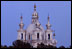 The moon rises at sunset in St. Petersburg, Russia. 