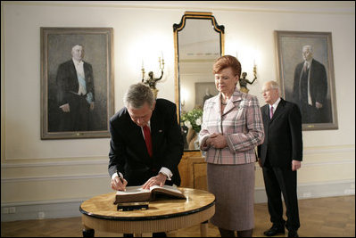 President George W. Bush signs a guest book after Latvian President Vaira Vike-Freiberga presented him the Order of the Three Stars, First-Class at Riga Castle in Riga, Latvia, Saturday, May 7, 2005. Established in 1924 to commemorate the founding of the Latvian State, the medal is awarded to recognize outstanding civil merit in the service of Latvia.