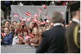 President George W. Bush turns to a crowd waving American and Latvian flag while visiting the Freedom Monument in Riga, May 7, 2005.