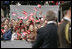 President George W. Bush turns to a crowd waving American and Latvian flag while visiting the Freedom Monument in Riga, May 7, 2005.