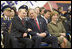 President George W. Bush and Russian President Vladimir Putin share a light moment as they sit with Laura Bush and other heads of state during a military parade marking the end of World War II in Moscow's Red Square, Monday, May 9, 2005.