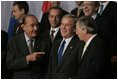 President George W. Bush talks with French President Jacques Chirac, left, and European Union President Jean-Claude Juncker as world leaders take their places for the official NATO group photo in Brussels Tuesday, Feb. 22, 2005. 