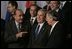 President George W. Bush talks with French President Jacques Chirac, left, and European Union President Jean-Claude Juncker as world leaders take their places for the official NATO group photo in Brussels Tuesday, Feb. 22, 2005. 