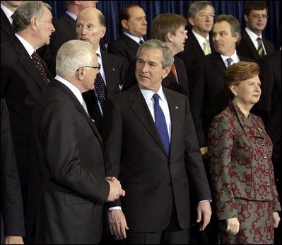 President George W. Bush speaks with Czech President Vaclav Klaus as world leaders take their place for the official NATO photo at the NATO Headquarters in Brussels Tuesday, Feb. 22, 2005. 