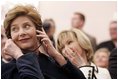 Laura Bush listens to translation headphones during a joint press conference with President George W. Bush and German Chancellor Gerhard Schroeder at the Electoral Palace in Mainz, Germany, Wednesday, Feb. 23, 2005. The Chancellor.s wife, Mrs. Schroeder-Koepf is seated next to Mrs. Bush.