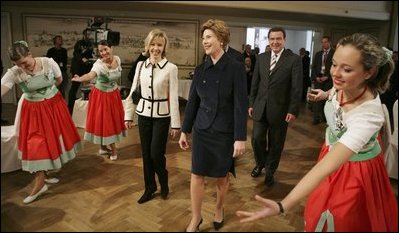 Laura Bush watches dancers during a Wednesday, Feb. 23, 2005, lunch hosted by Chancellor Gerhard Schroeder, behind, and Mrs. Schroeder-Koepf, left, at the Electoral Palace in Mainz, Germany.