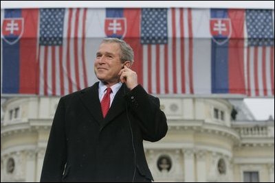 President George Bush listens to Slovak Prime Minister Mikulas Dzurinda's introduction before giving remarks at Hviezdoslavovo Square in Bratislava, Slovakia, Feb. 24, 2005.