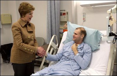 Laura Bush visits with U.S. Army Specialist Garrett Larson who is recovering from injuries sustained in Iraq at the Landstuhl Regional Medical Center Tuesday, Feb. 22, 2005, in Ramstein, Germany. 