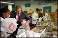 President George W. Bush and Laura Bush help volunteers pack food during their visit to the Capital Area Food Bank in Washington, D.C., Thursday, Dec. 19. "More Americans need to volunteer. There are ways to do so. The USAFreedomCorps.gov on the web page is the place to look," said the President in his remarks. "You can call 1-877-USA-CORPS and find out ways that you can help. If you are interested in being a part of feeding those who hunger, this is a great place to come to." 