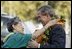 President Bush is greeted by USA Freedom Corps Greeter Hilma Chang at Hickam Air Force Base in Honolulu, Hawaii, Oct. 23, 2003.