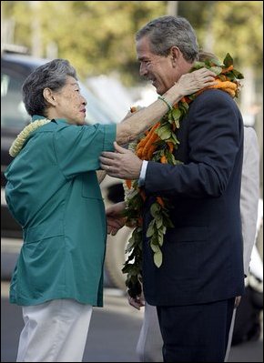 President Bush is greeted by USA Freedom Corps Greeter Hilma Chang at Hickam Air Force Base in Honolulu, Hawaii, Oct. 23, 2003.