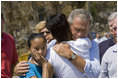 President George W. Bush comforts Bronwynne Bassier, right, and her sister Kim after landing in Biloxi, Miss., Friday Sept. 2, 2005, as part of his tour of the Hurricane Katrina-ravaged Gulf Coast. Their family lost everything in the wake of the devastating storm.