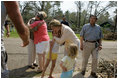 Laura Bush visits with a family outside their hurricane-damaged home, Monday, Sept. 5, 2005, on West Ida Street in Poplarville, Miss. President George W. Bush and Mrs. Bush made the visit during their trip through the hurricane ravaged areas of the Gulf Coast.