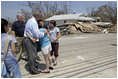 President George W. Bush comforts a family during his walking tour through neighborhoods damaged by Hurricane Katrina in Biloxi, Miss., Sept. 2, 2005.