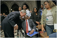 President George W. Bush greets one of the Hurricane Katrina evacuees attending the National Day of Prayer and Remembrance Service at the Washington National Cathedral in Washington, D.C., Friday, Sept. 16, 2005.