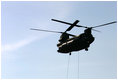 Helicopters lift sandbags that will be dropped into the area of the levee break to facilitate repairs to 17th street levee in New Orleans, Louisiana Thursday, September 8, 2005.