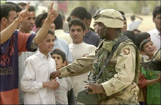 Iraqis share a laugh with a U.S. Army soldier during an effort to distribute food and water to Iraqi citizens in need.